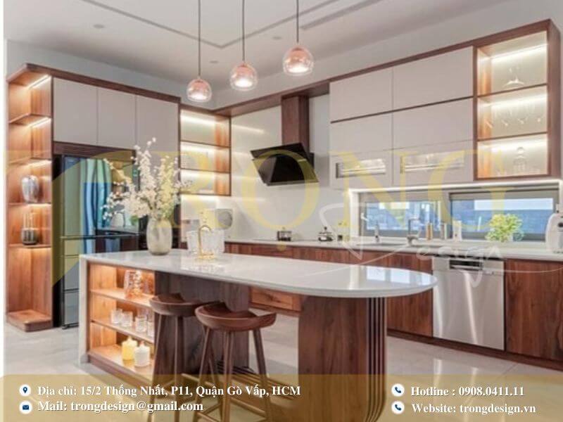 Bếp hiện đại ấm cúng với gỗ óc chó, đảo bếp liền bàn ăn và đèn trần cánh quạt.