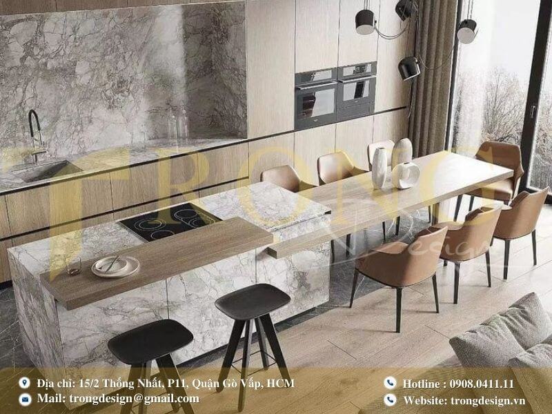 Bếp hiện đại với tủ bếp màu be bóng và bàn ăn nhỏ liền kề đảo bếp.