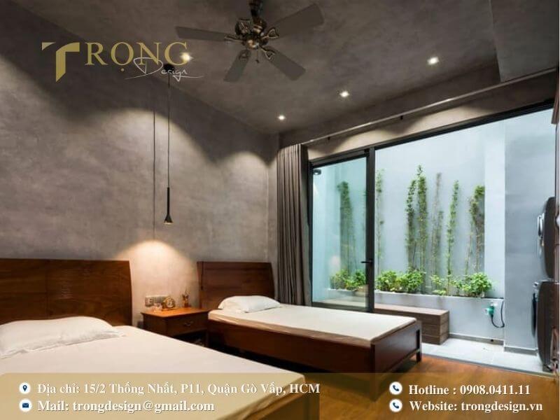 Phòng ngủ mộc mạc và gần gũi thiên nhiên với hai giường đơn và sân vườn nhỏ.