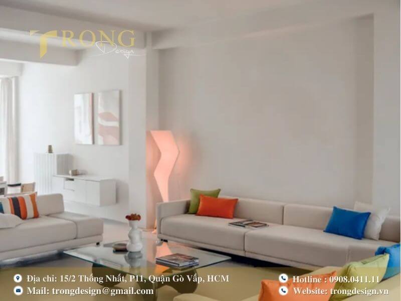Phòng khách tối giản, phá cách với các gối tựa đầy màu sắc trên nền nội thất trắng.